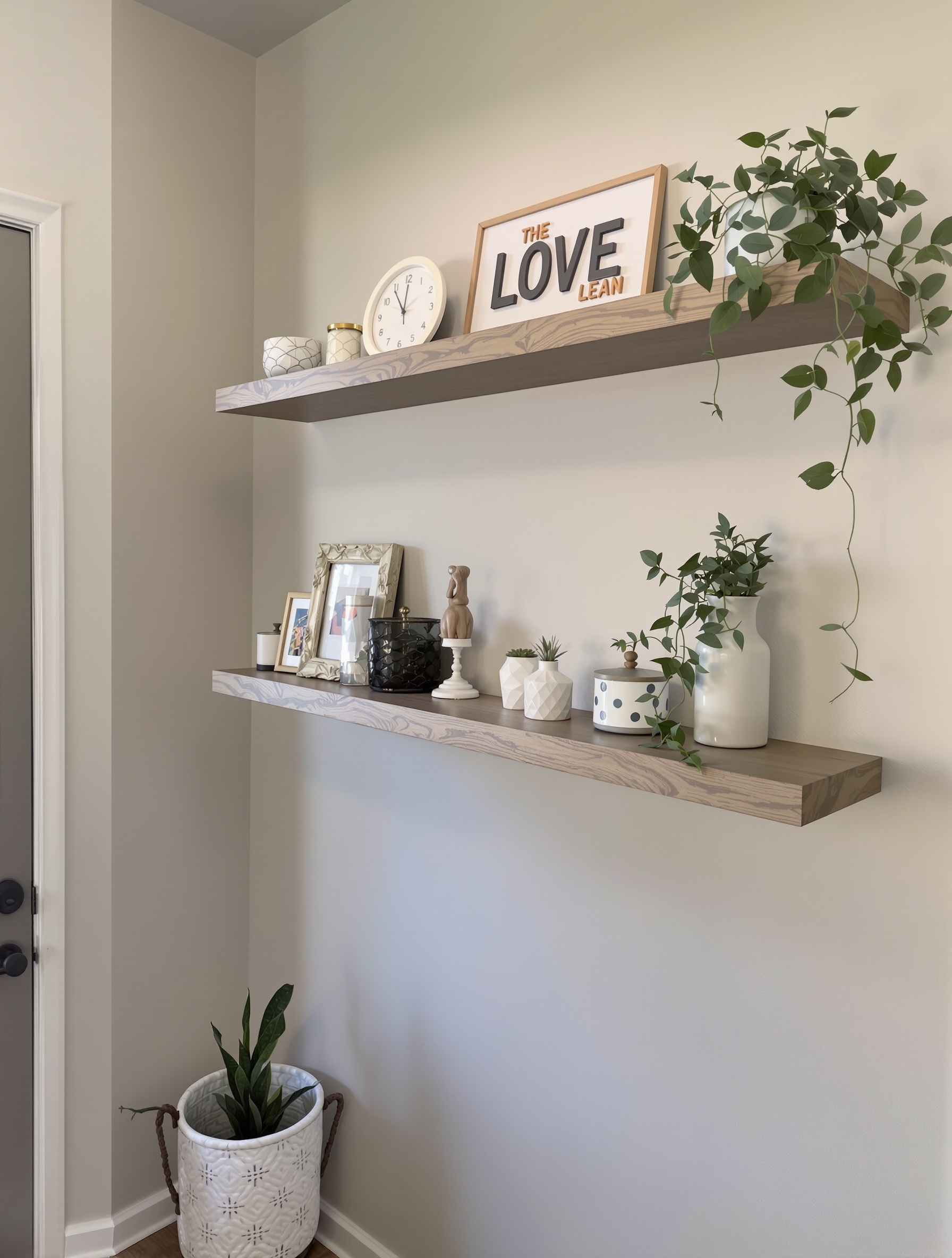 Floating shelves in a small entryway displaying plants, decorative items, and a clock.